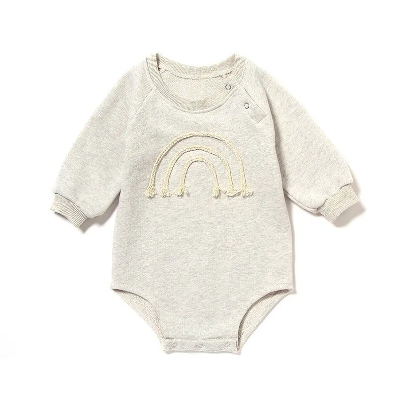 Neutral baby romper in waffle cotton fabric with long sleeves, shown in beige with cotton rope detail.