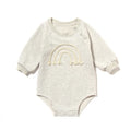 Neutral baby romper in waffle cotton fabric with long sleeves, shown in beige with cotton rope detail.