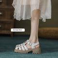 Women's black retro platform sandals with closed toe, hollow sides, chunky heel, and a buckle fastening.