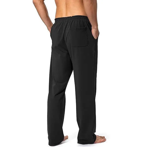 Men's loose fit casual trousers in black polyester fabric on a hanger.
