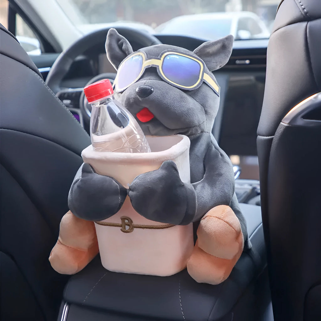 Plush car tissue box holder hanging from flip-down armrest with humorous dog design