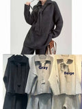 Women's dark grey acrylic knit sweater suit two-piece set with long sleeves and casual trousers.