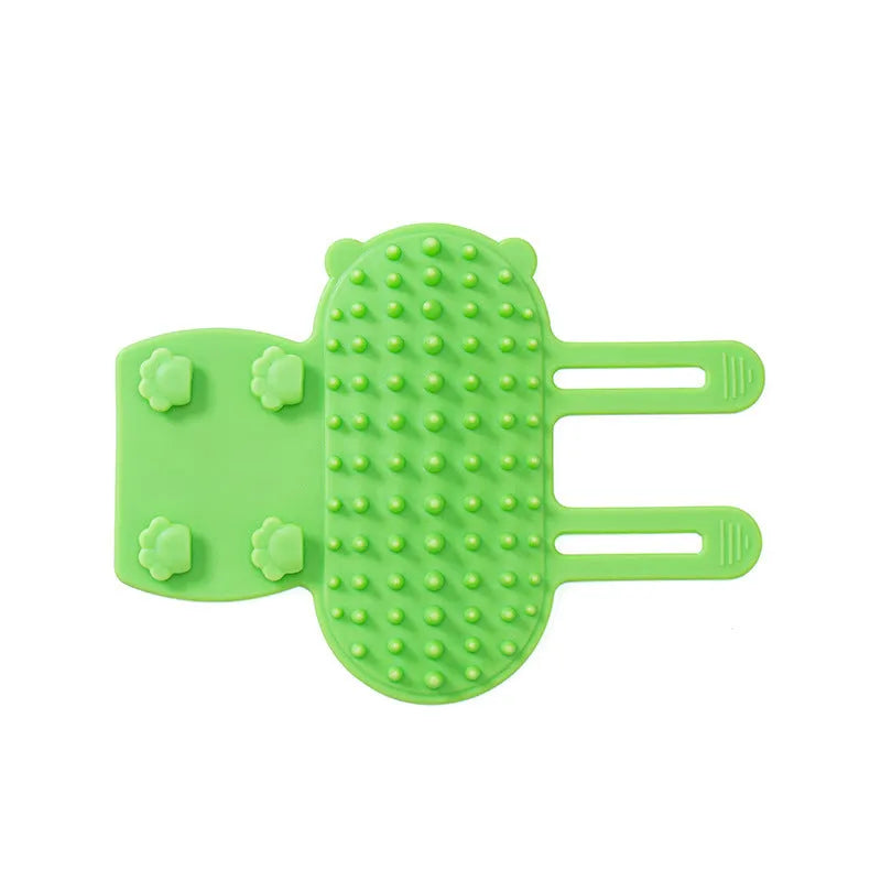 Black silicone cat grooming comb with rounded teeth and adjustable mounting strap for table legs.