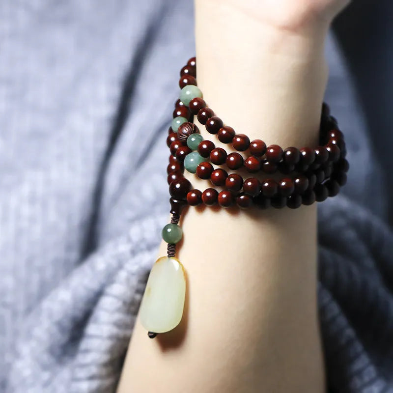 Rosewood bead bracelet with 108 beads and a carved green Hotian jade pendant.