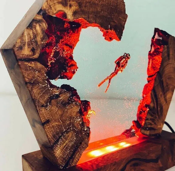 Resin luminous diver and humpback whale night light with USB cable on a shelf