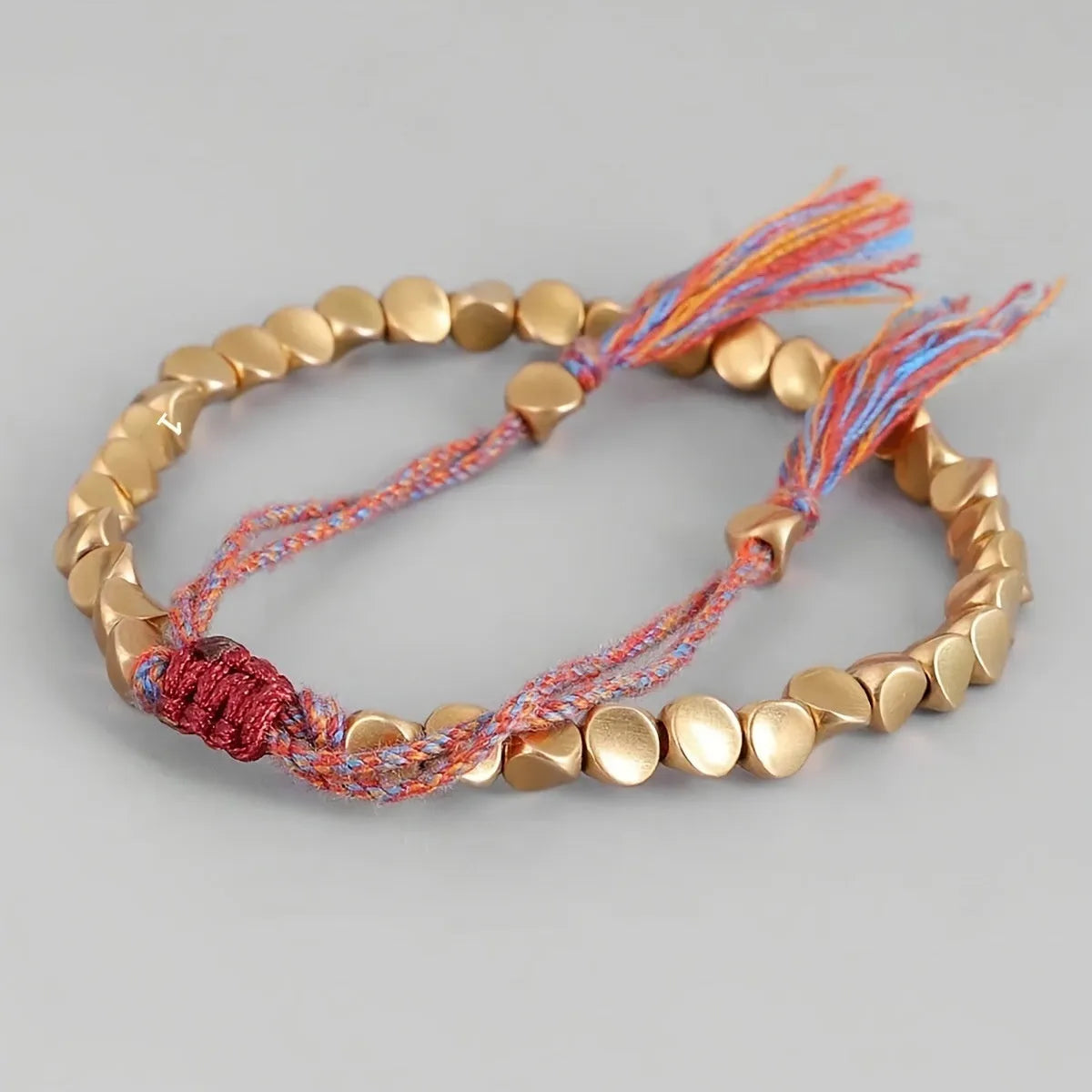 Hand-woven adjustable alloy tassel bracelet in electroplated colour T131 on neutral background