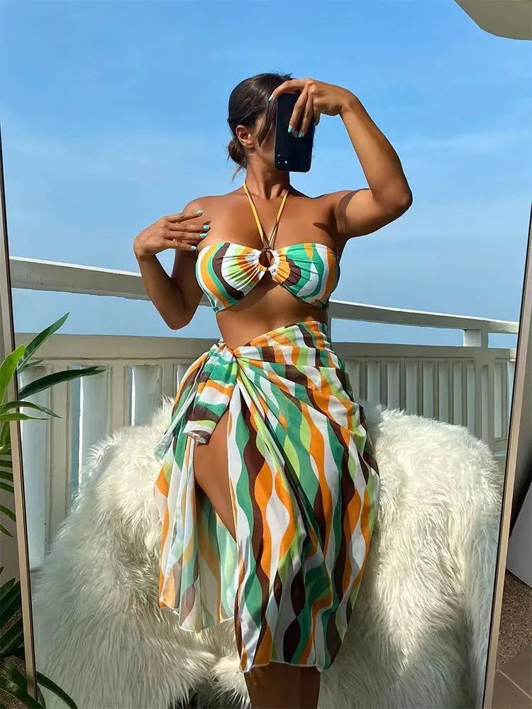 Women's yellow green printed three-piece bikini set with a matching skirt laid flat.