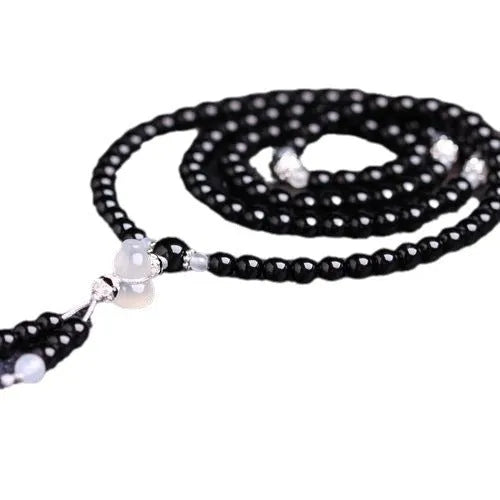 Black agate beaded bracelet with 108 geometric beads and number elements on wrist