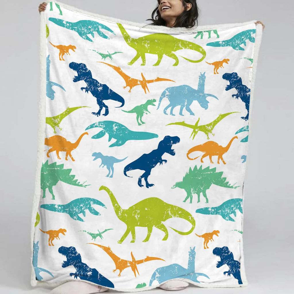 Dinosaur themed white sherpa fleece lamb wool blanket folded on a sofa