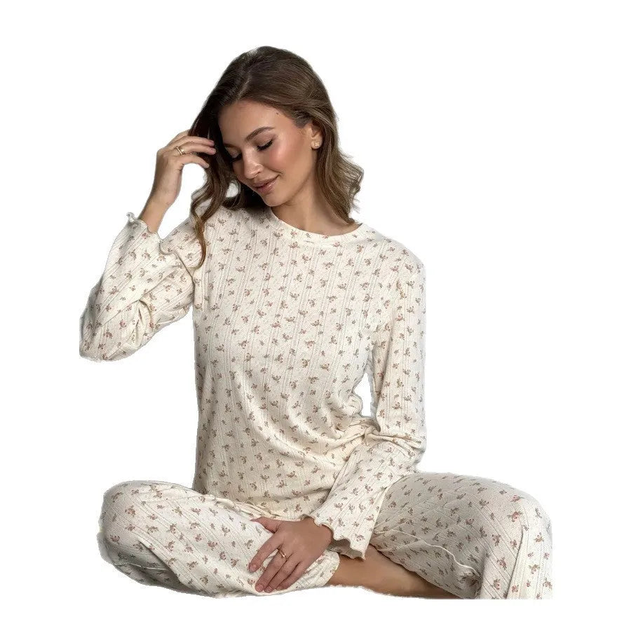 White floral print women's suit with bell sleeve top and wide-leg trousers laid flat