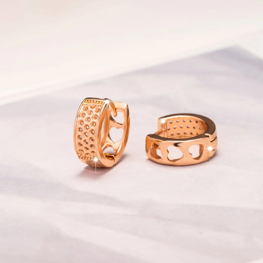 Rose gold tone women's earrings with a hollowed-out heart shape divided into three sections.