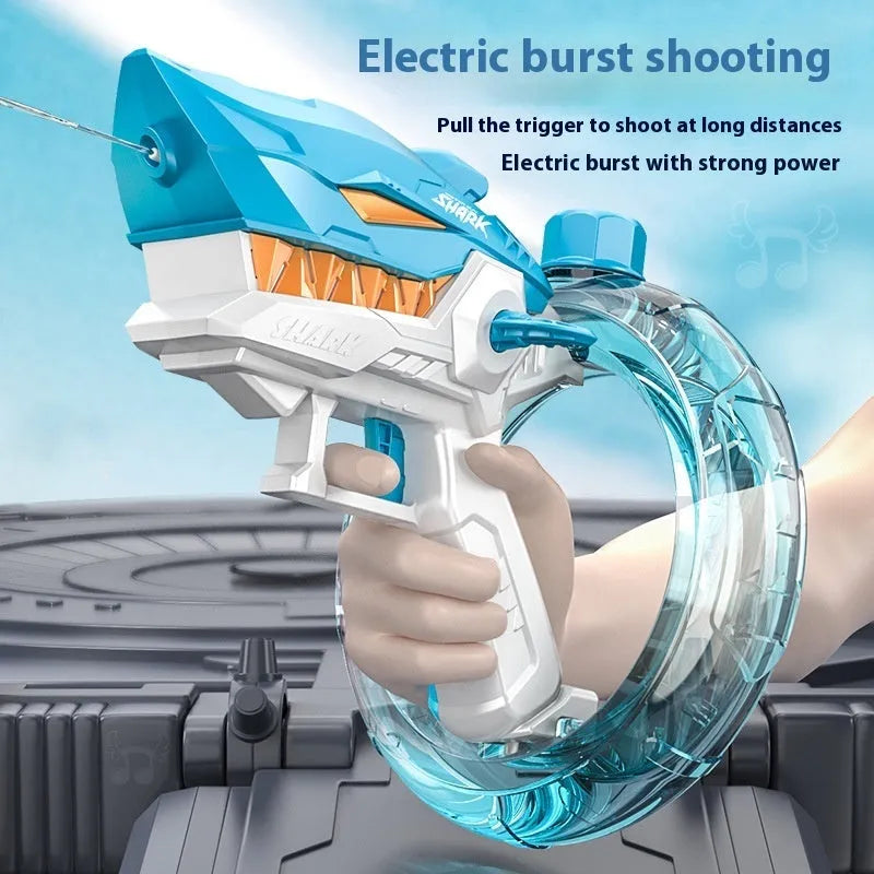 Blue Shark-shaped electric water gun toy with large tank on a summer beach.