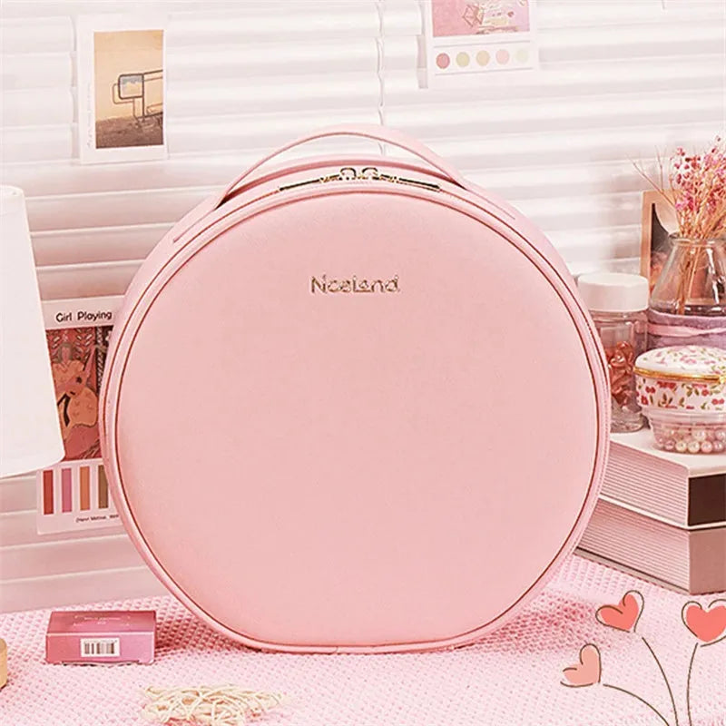 Round pink PU leather makeup bag with LED mirror open, showing internal partitions and carry strap.