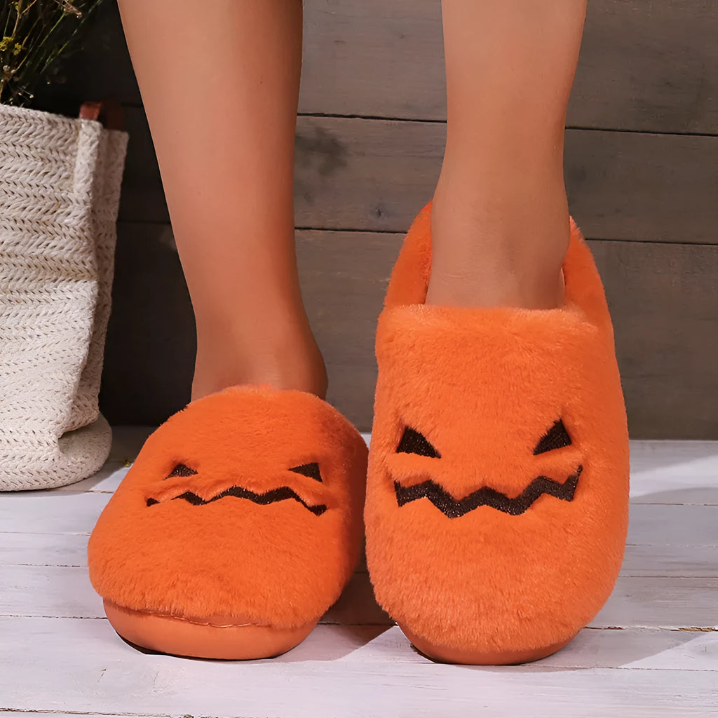 Orange Halloween pumpkin-themed plush indoor slippers with a coral velvet upper and non-slip PVC sole.