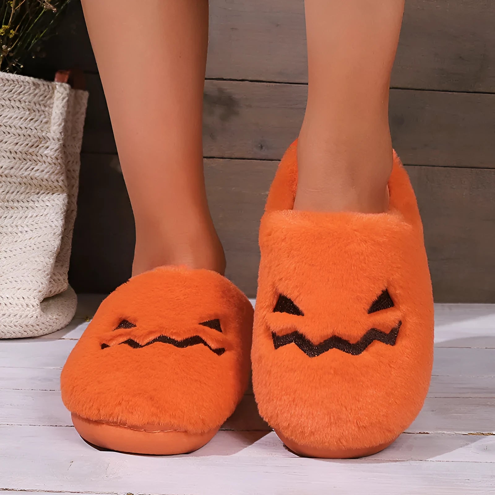 Orange Halloween pumpkin-themed plush indoor slippers with a coral velvet upper and non-slip PVC sole.