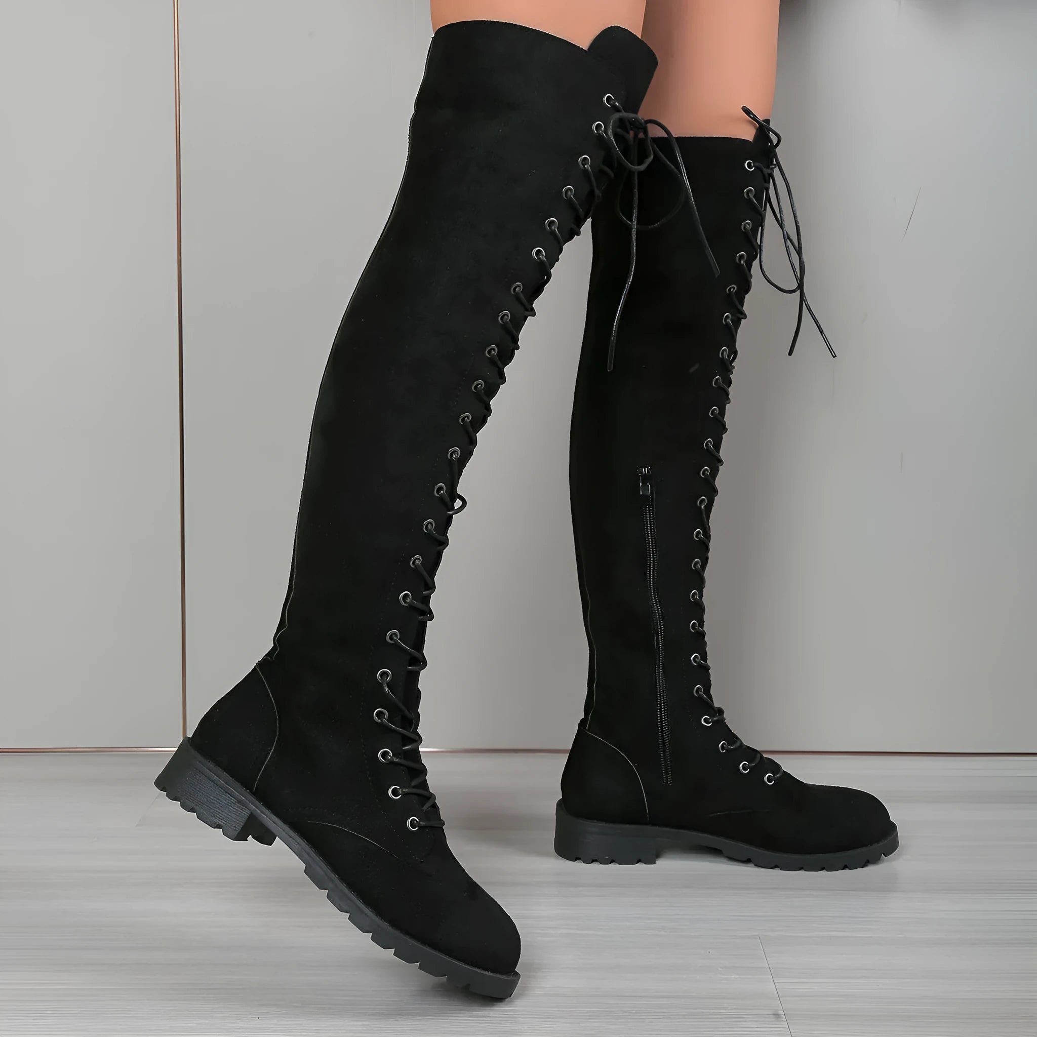 Black lace-up over the knee boots with round toe, flat heel, and decorative stitching.