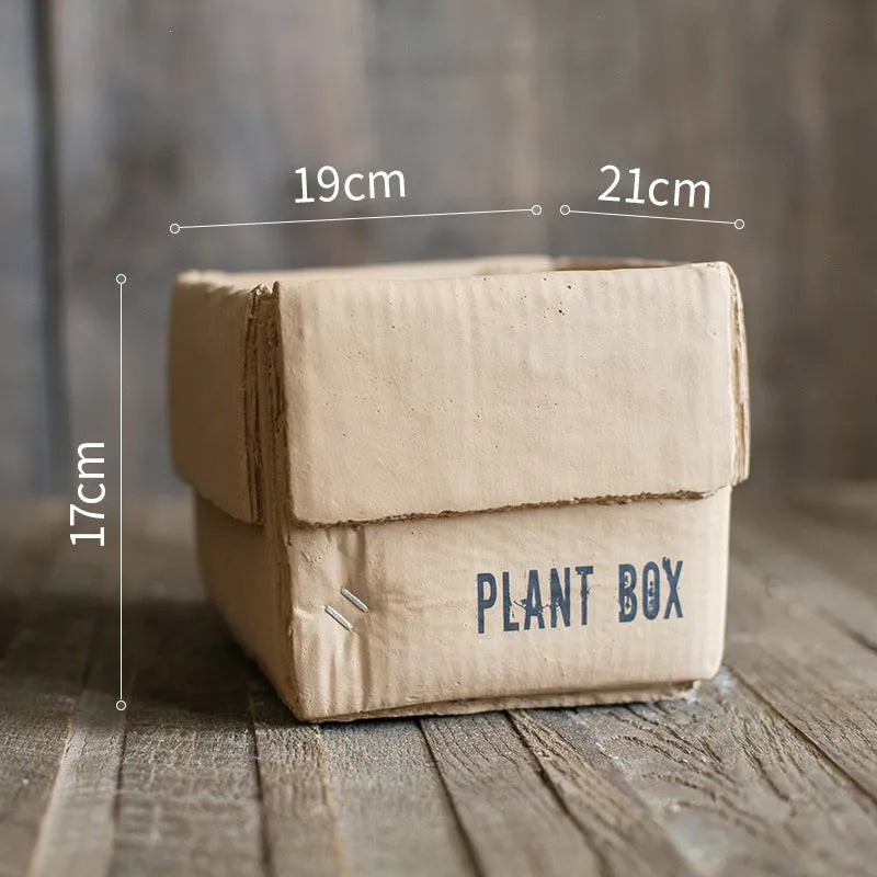 Cement flowerpot with brown paper carton design and drainage hole for indoor balcony plants.