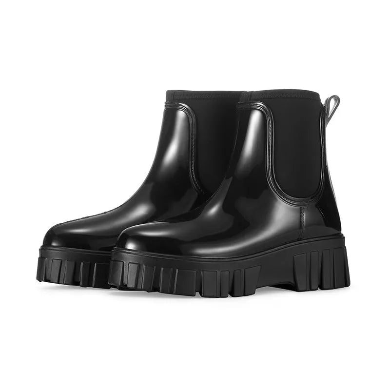 Women's creamy-white PVC rain boots with low tube shaft and flat heel on wet surface