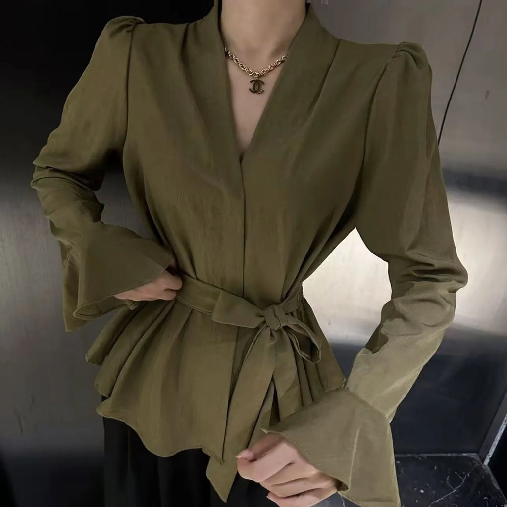 Women's black French-style shirt with an irregular collar and long bell sleeves, showing the tied front detail.