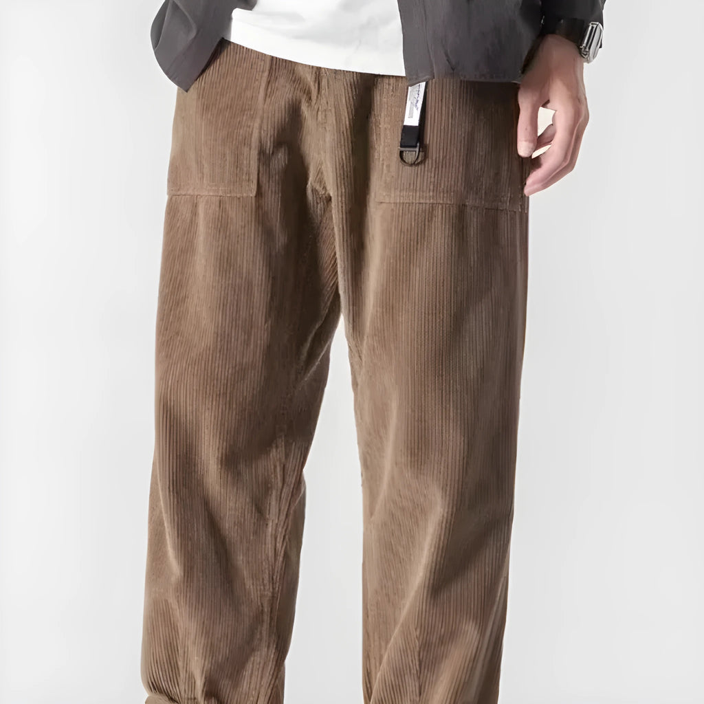 Man wearing loose straight-leg tapered trousers in dark grey, showing the full length and relaxed fit.