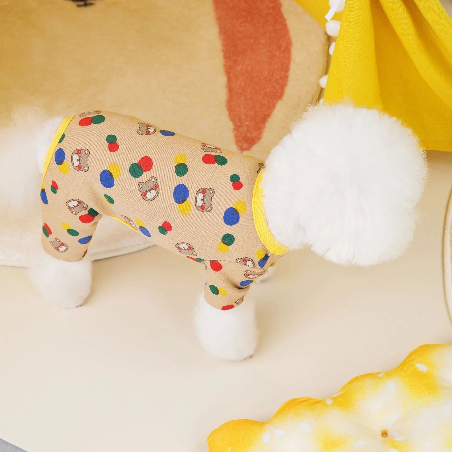 Beige dog t-shirt with a colourful cartoon ball bear design, showing a casual fit on a pet.