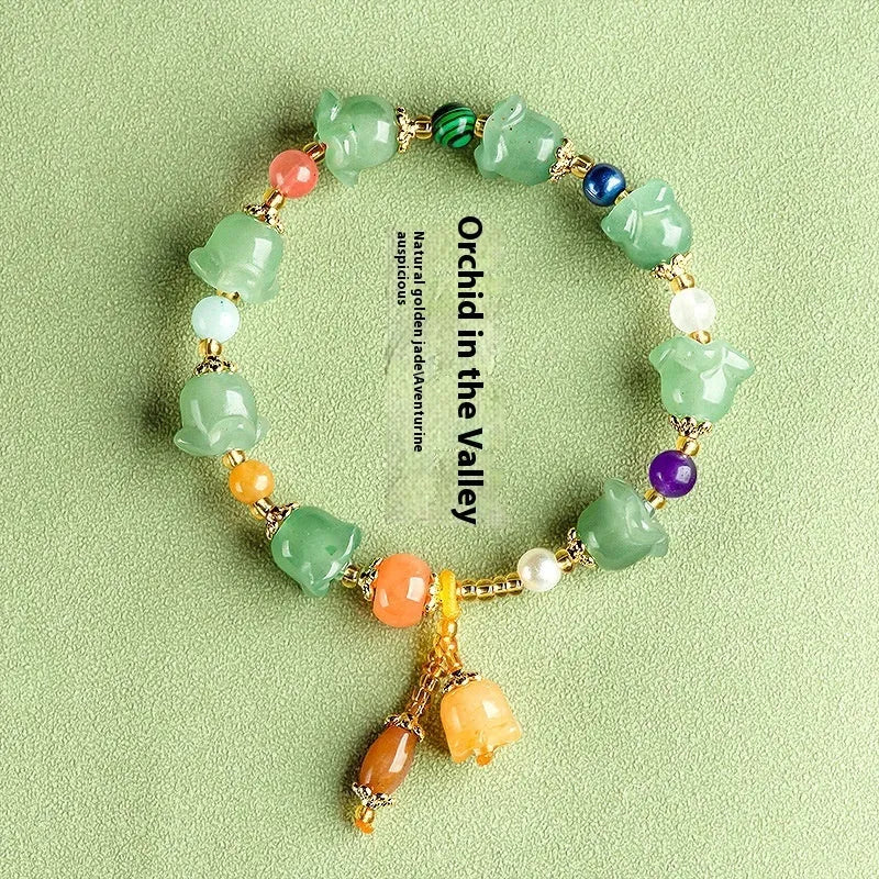 Natural Xinjiang Jinsi Jade bracelet with carved aventurine orchid beads on a wrist.
