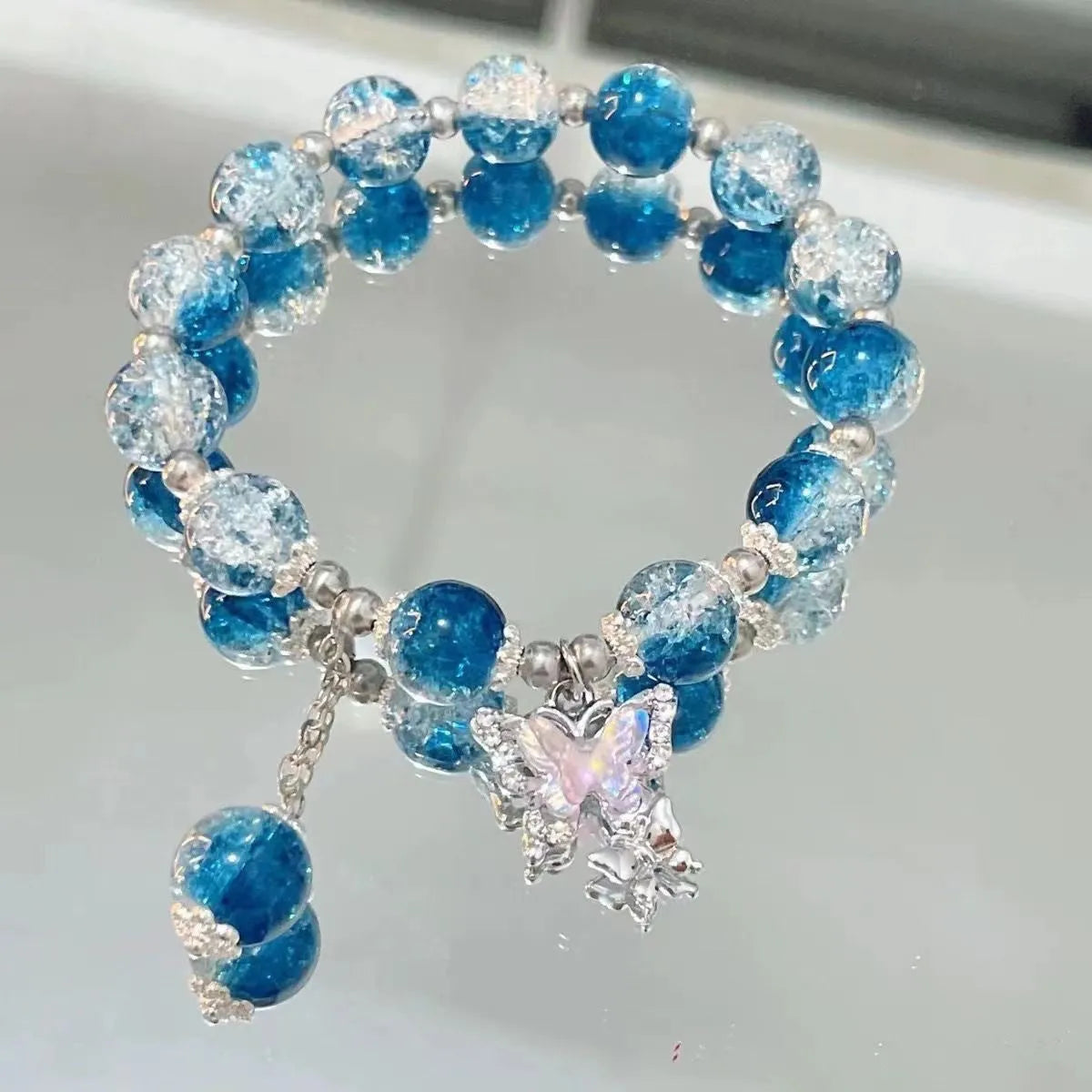 Handmade glass bead bracelet with fairy butterfly broken beads design on white background