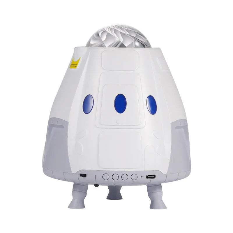 Space capsule shaped USB galaxy projection lamp with remote control on a surface.