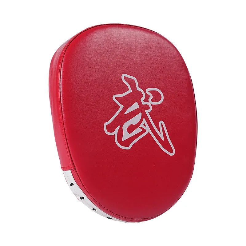 Red and black curved boxing punch mitts held in a trainer's hands for Muay Thai or Sanda practice.