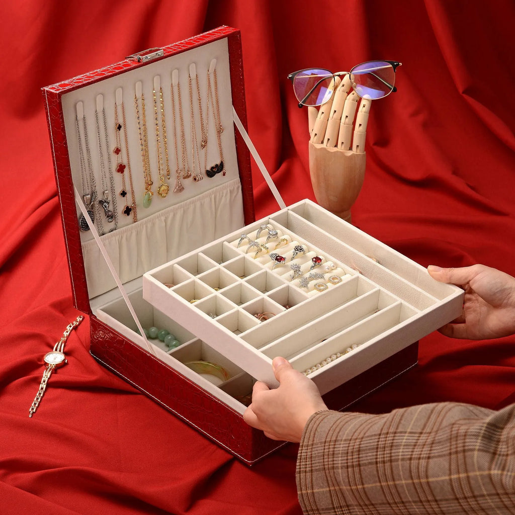 Green fashion leather double layer jewellery storage box with lock on wood.