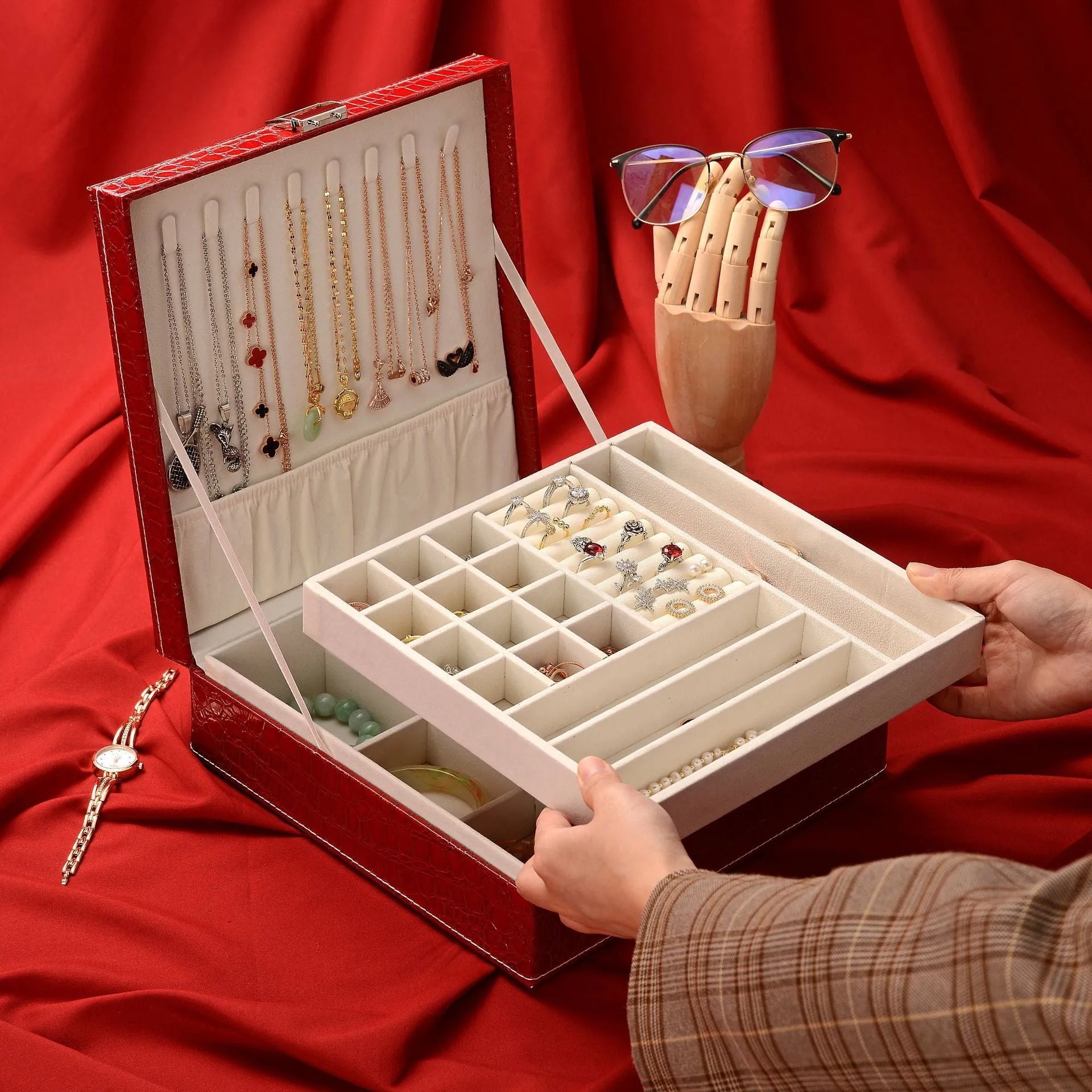Green fashion leather double layer jewellery storage box with lock on wood.