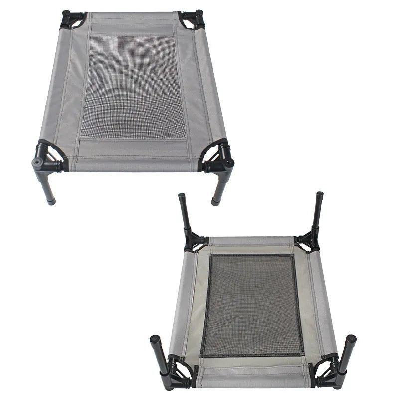 Black Oxford cloth outdoor dog bed with steel frame, shown on grass for camping use.