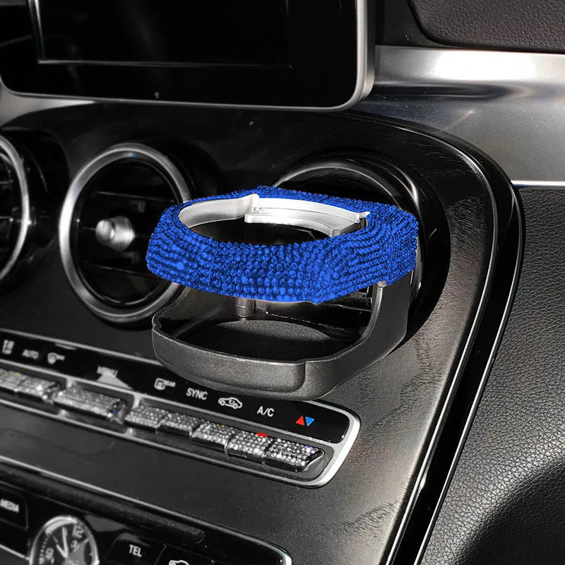 White diamond-decorated car cup holder bracket clipped onto a vehicle air vent.