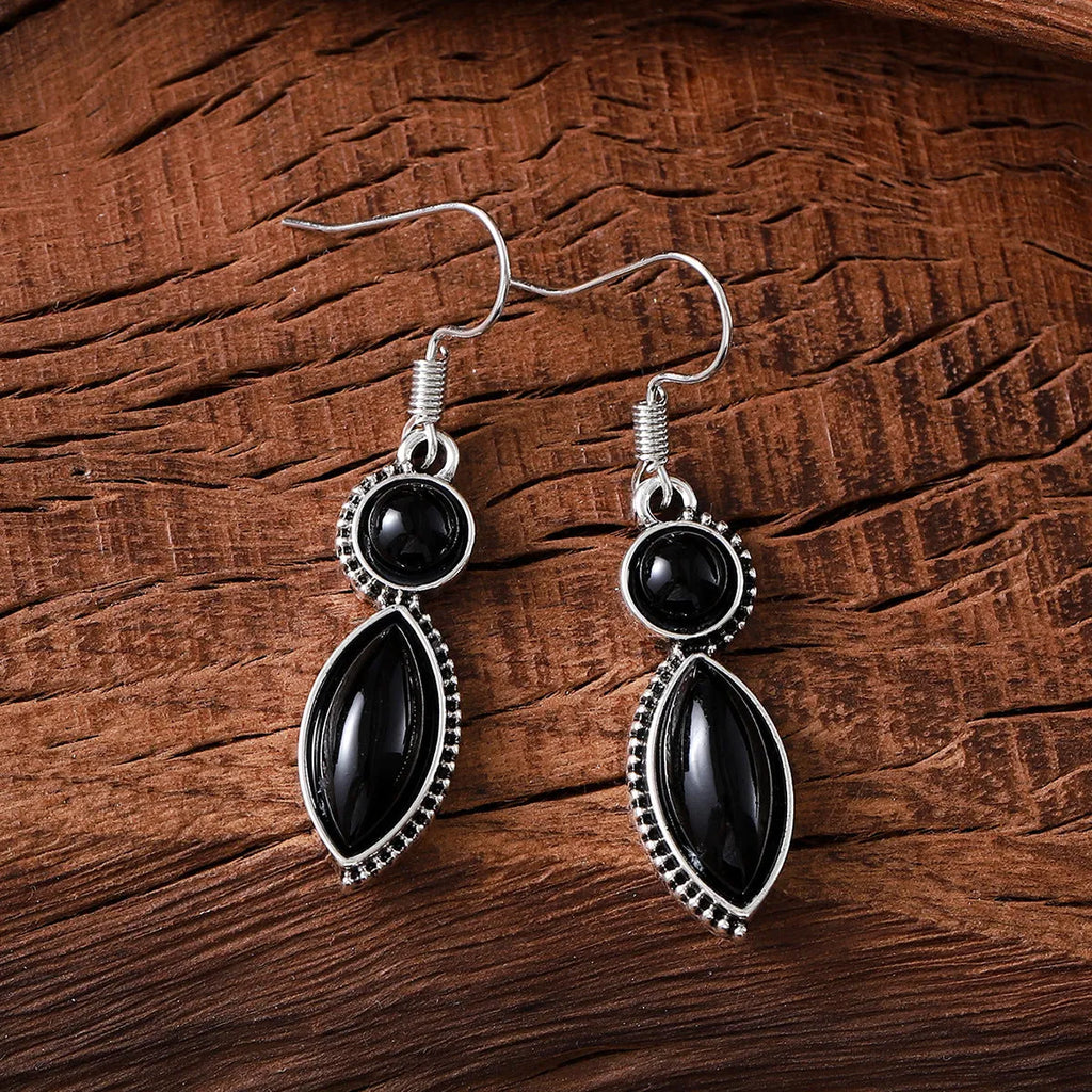 A pair of vintage geometric drop earrings with a round gemstone, in black and purple electroplated zinc alloy.