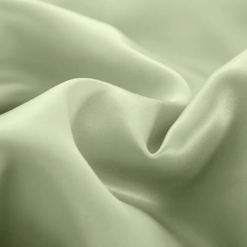 Double-sided silk duvet cover in plain weave, shown in one of six solid colours, laid flat on a bed.