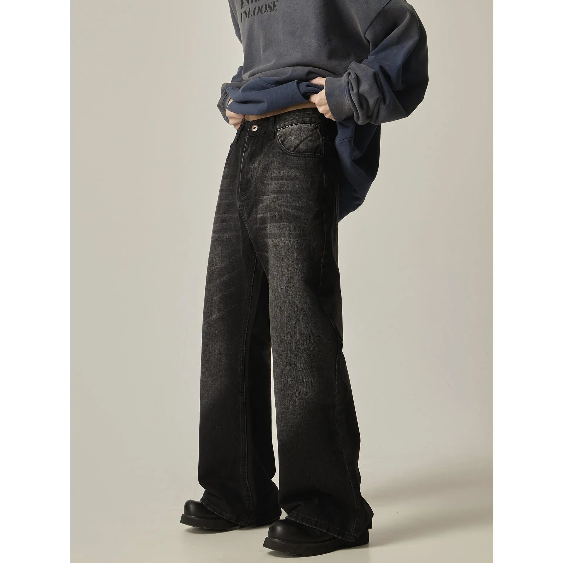 Black loose-fit straight-leg retro jeans with zipper fly on a plain background.