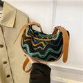 Women's straw woven crossbody bag showing woven texture and adjustable strap with internal phone and document pockets