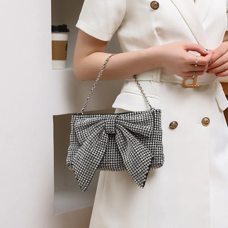 Crystal rhinestone bow crossbody bag with single shoulder chain strap in silver, AB colour silver, black, light gold, or pink.