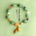 Natural Xinjiang Jinsi Jade bracelet with carved aventurine orchid beads on a wrist.