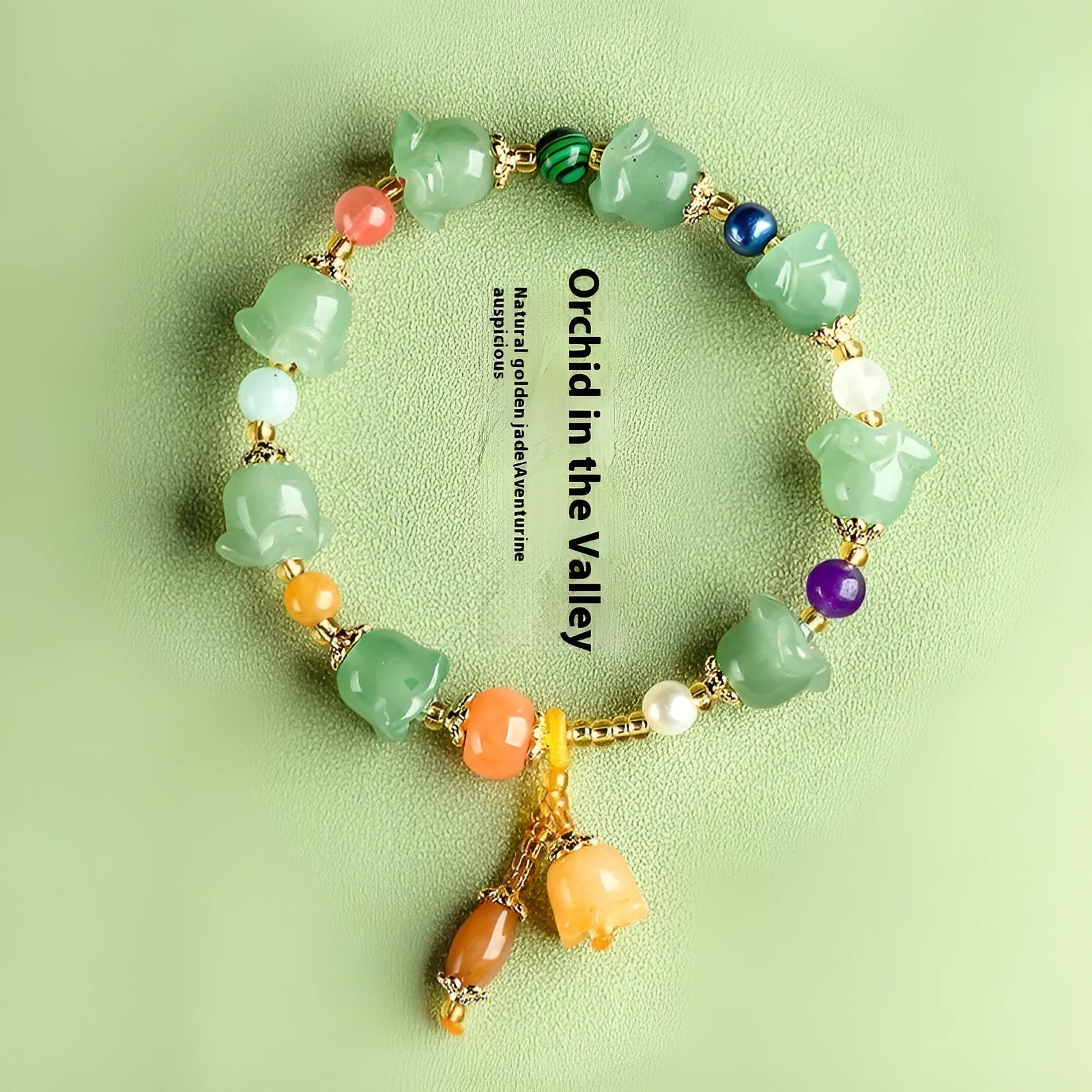 Natural Xinjiang Jinsi Jade bracelet with carved aventurine orchid beads on a wrist.