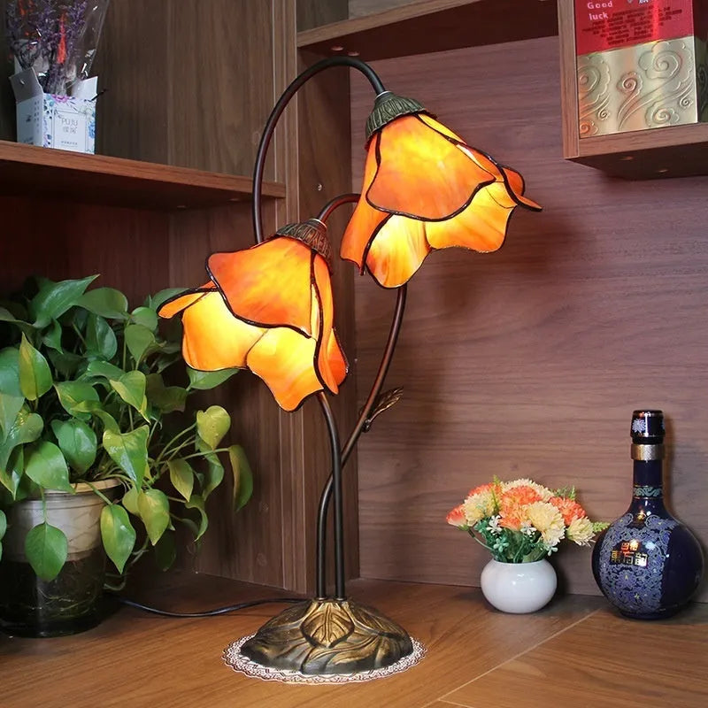 Retro American style table lamp with coloured glass lotus design shade on wooden surface
