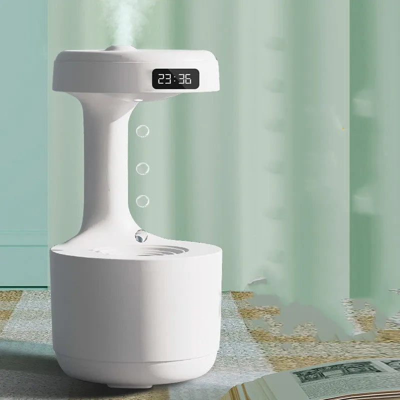 White anti-gravity humidifier with LED clock display emitting mist on a wooden desk.