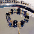 Women's bracelet with snowflake pendant and bow charm in galaxy colours on alloy construction