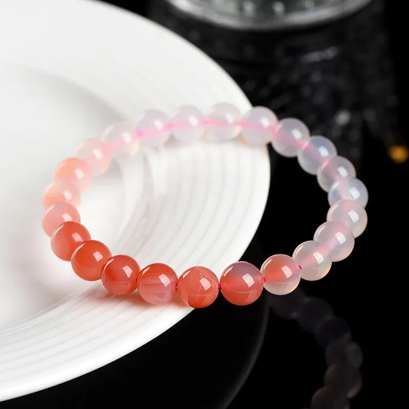 Natural gradient Yanyuan agate bracelet with geometric cut beads on a wrist.