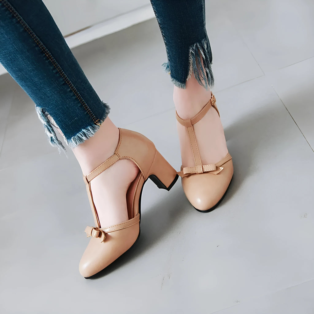 Yellow women's chunky heel sandals with a buckle strap and bow detail on a hollow-out round toe.