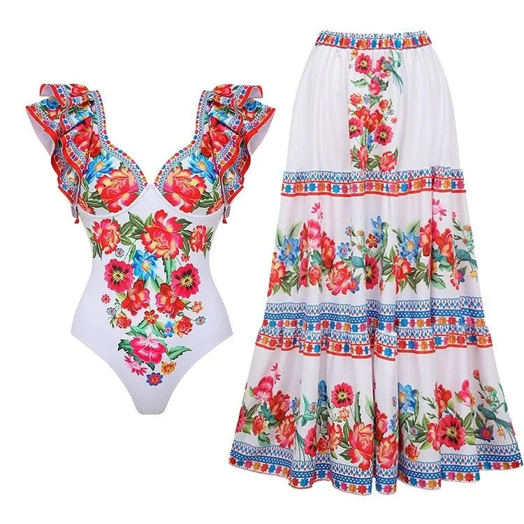 Women's printed one-piece swimsuit on a hanger showing rose pink, white, and blue colour variations.
