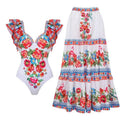 Women's printed one-piece swimsuit on a hanger showing rose pink, white, and blue colour variations.