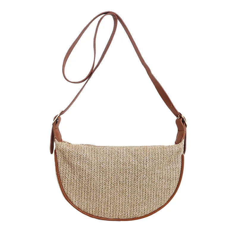Women's straw woven crossbody bag showing woven texture and adjustable strap with internal phone and document pockets