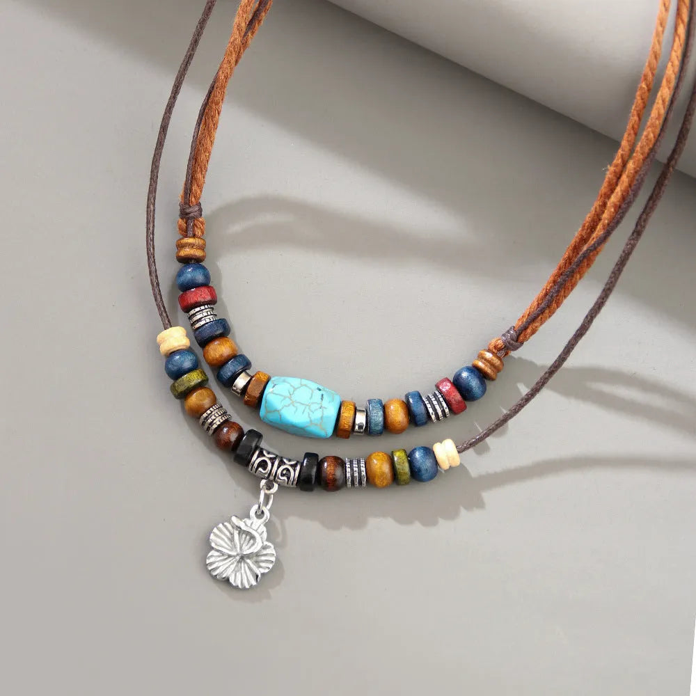 Men's retro necklace with geometric flower pendant and turquoise wooden beads on a wax rope chain.