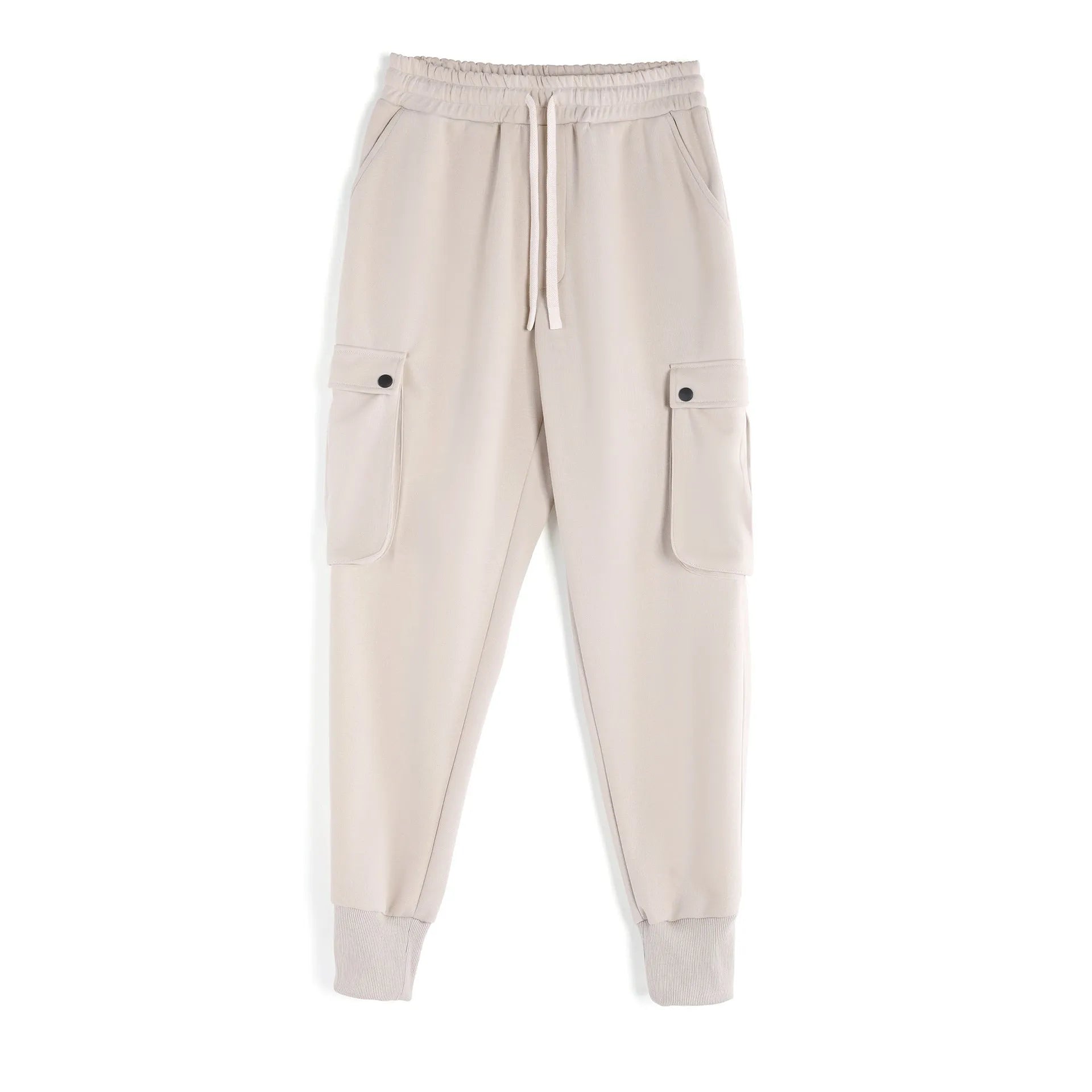 Men's loose beige cotton trousers with an ankle tie and multiple pockets on a casual model.